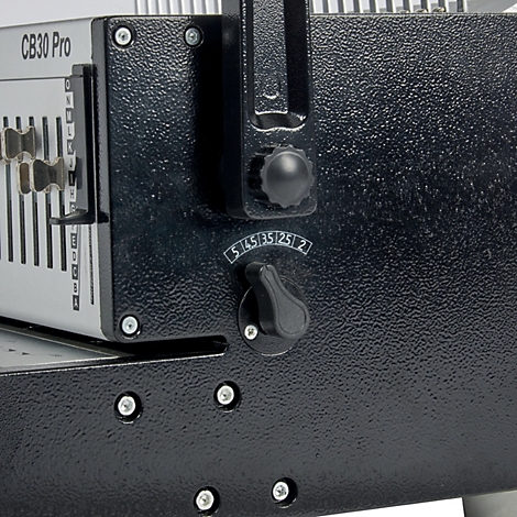 Close-up van een zwarte bindmachine. Details zijn een draaiknop, een handvat, schroeven en het 'CB30 Pro'-logo.