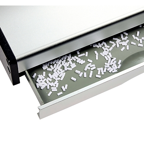 Gros plan sur un appareil argenté avec un tiroir rempli d'objets blancs cylindriques.