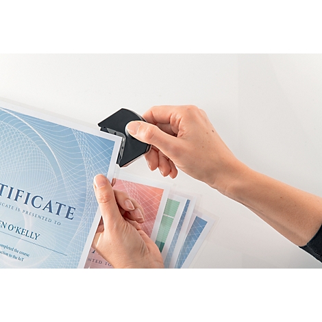 Handen die een zwarte hoekronder gebruiken om certificaten te trimmen. Blauwe certificaatsjabloon met het woord 'Certificate'.