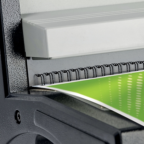 Gros plan d'une relieuse noire reliant un document avec un fond vert. Il y a une partie blanche en haut.