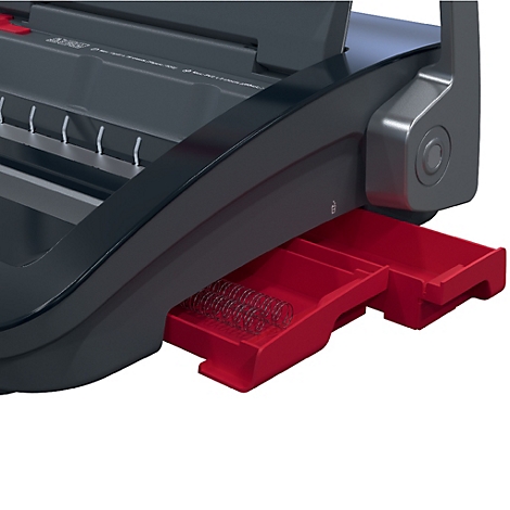 Detailaufnahme einer schwarzen Bindemaschine mit roter Auffangschale für Spiralen.