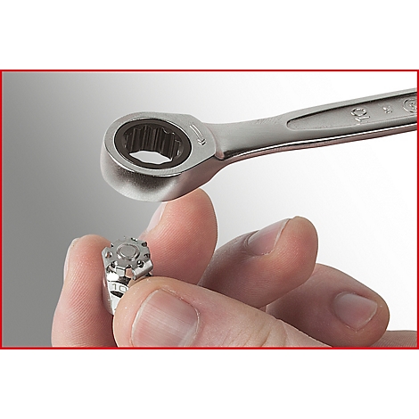 Nahaufnahme: Hand hält Schraube, daneben ein Schraubenschlüssel.