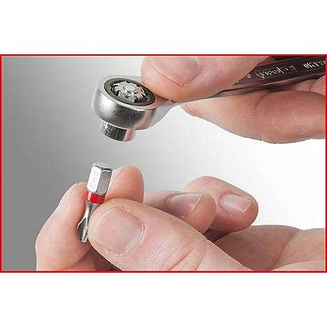 Nahaufnahme eines Schraubenschlüssels und einer Schraube, die von Händen gehalten werden.