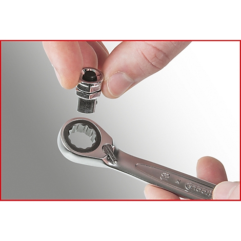 Hand hält eine Sechskantnuss, die auf einen Ratschenschlüssel aufgesetzt wird. Der Schlüssel und die Nuss sind aus Metall.