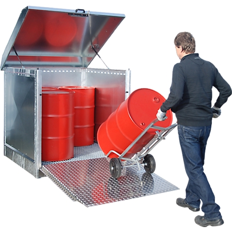 Ein Mann zieht eine rote Tonne auf einem Transportwagen aus einem silbernen Lager. Im Lager stehen weitere Tonnen.