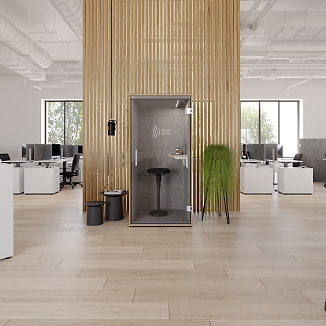 Kantoor met houten vloer en een geluiddichte telefooncel. Heldere, moderne sfeer. Naast de cabine staan twee kleine zwarte krukken.