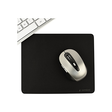 Drahtlose Maus auf schwarzem Mousepad, Tastatur im Hintergrund.