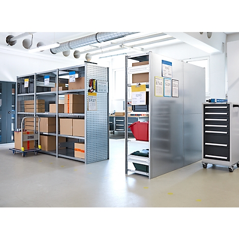 Magazijn met metalen planken, kartonnen dozen, gereedschapskar. Heldere omgeving, witte vloer.
