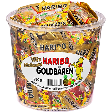 Ein großer, transparenter Behälter gefüllt mit Haribo Goldbären in kleinen, goldfarbenen Beuteln. Auf dem Behälter ist ein Etikett mit dem Haribo-Logo und der Aufschrift "Goldbären" zu sehen.