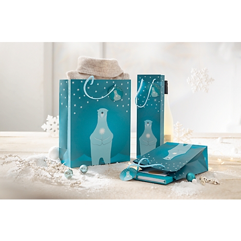 Cadeautassen met ijsbeermotieven, gedeeltelijk gevuld met items. Decoratie met sneeuwvlokken en sneeuw op de achtergrond.