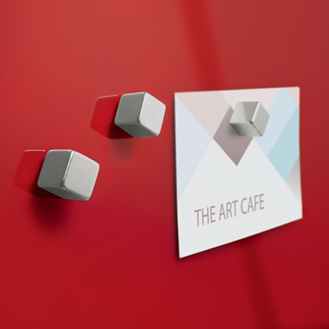 Rote Magnete halten Notiz an roter Oberfläche fest. Auf der Notiz steht "THE ART CAFE".