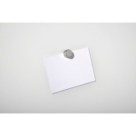 A white memo pad, attached to a white surface with a round, silver magnet.