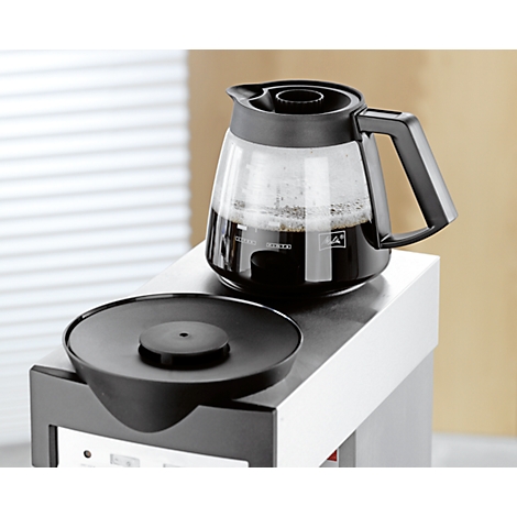 Glass coffee pot with freshly brewed coffee on a coffee machine. Black jug with handle.