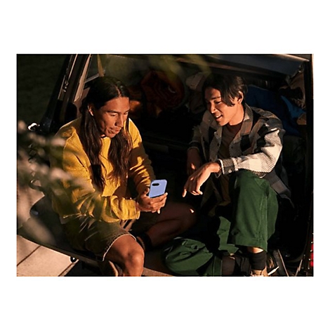 Zwei Männer sitzen im Kofferraum eines Autos und schauen auf ein blaues Smartphone. Einer trägt ein gelbes Sweatshirt, der andere ein kariertes Hemd.