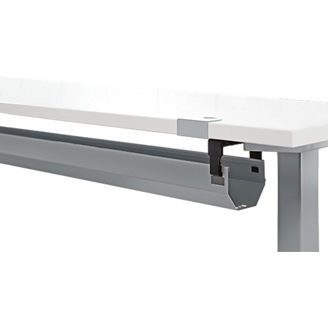 Goulotte de câbles grise sous un plateau de table blanc, fixée avec des supports noirs.