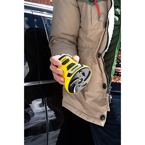 Une personne tient un appareil jaune et rond. Il comporte des éléments noirs et une hélice grise.