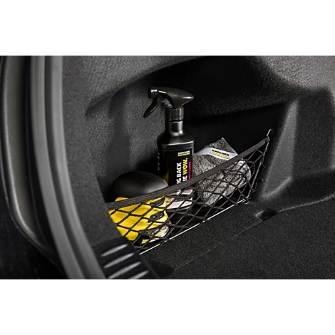 Gros plan d'un espace de rangement de voiture avec des produits de nettoyage. Un vaporisateur est posé à côté d'éponges et de chiffons en microfibre.