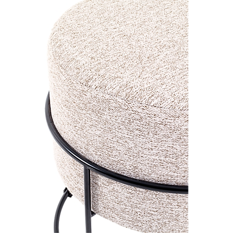 Close-up van een ronde kruk met lichte, gevlekte stoffen bekleding en zwart metalen frame.