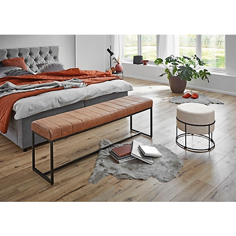 Ronde kruk met grijze stoffen bekleding en zwart metalen frame.