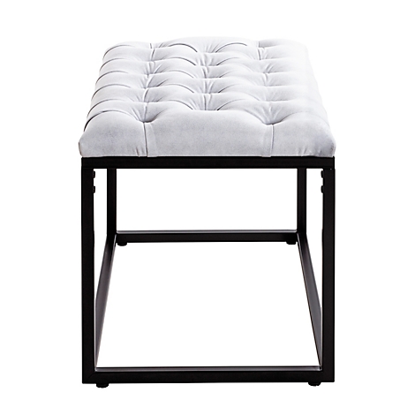 Gevulde ottoman met knoopontwerp. Lichtgrijze zitting, zwart metalen frame.