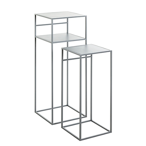 Deux tables d'appoint en métal gris, l'une haute avec deux étagères, l'autre basse avec une étagère.