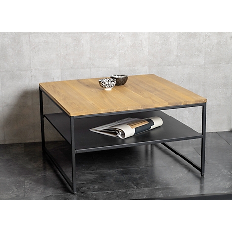 Table basse carrée avec plateau en bois, cadre noir et étagère. Deux bols, des magazines sont prêts.