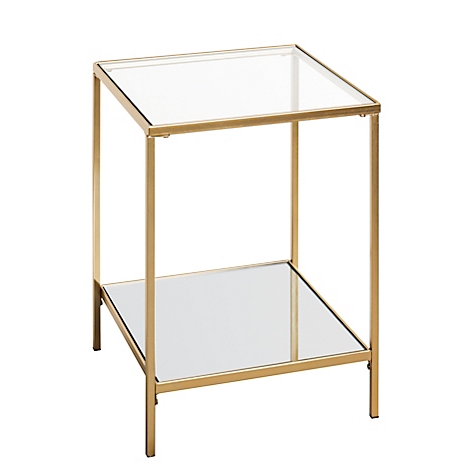 Une table d'appoint carrée avec une structure en métal doré et deux étagères en verre. L'étagère supérieure est transparente, l'inférieure est miroitante.