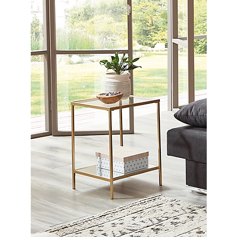 Table d'appoint avec plateau en verre, cadre doré, plante, bol, boîte. Devant la fenêtre, canapé à gauche.