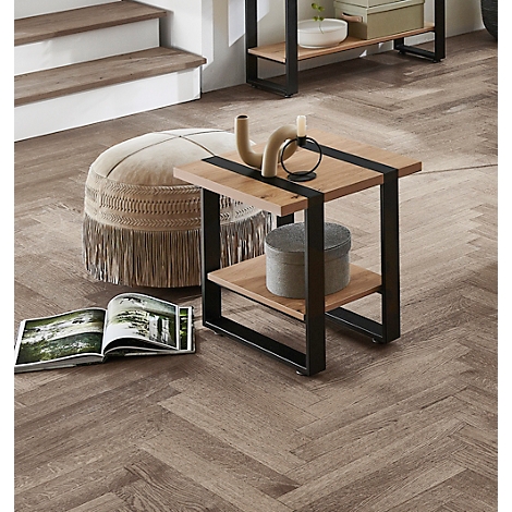 Table en bois avec cadre en métal, à côté un pouf, un magazine et de la décoration. Autres meubles en arrière-plan.