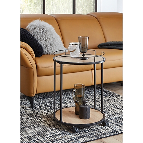 Détail d'une table d'appoint ronde en bois avec un cadre en métal noir.
