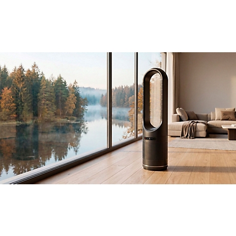 Zwarte torenventilator voor een raam met uitzicht op een meer en een bos. Op de achtergrond een bank.