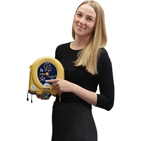 Lachende vrouw die een defibrillator vasthoudt en erop wijst.