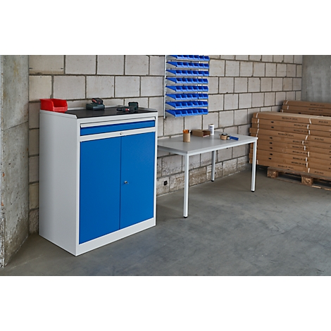Workshop cabinet in white and blue. Tools and a red container are on the worktop.