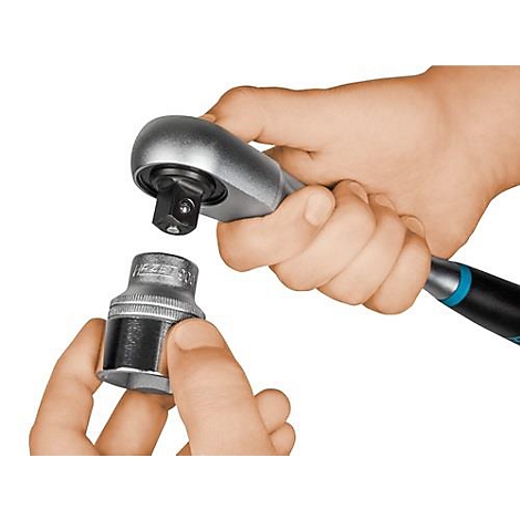 Handen die een dopsleutel op een ratel monteren. De focus ligt op de precieze interactie tussen gereedschap en accessoires.