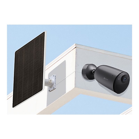 Eine dunkelgraue Ezviz-Überwachungskamera und ein angeschlossenes Solarpanel an einer weißen Gebäudeecke.