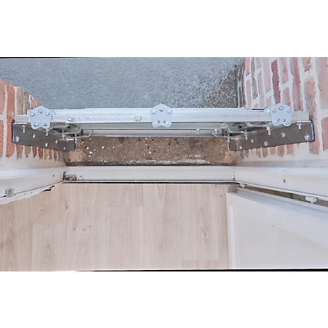 Detailaufnahme einer Türschwelle mit montierter Rampe. Metallkonstruktion, Ziegelwand, Holzfußboden.