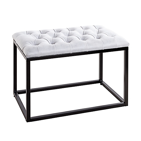 Hocker mit gepolsterter, hellgrauer Sitzfläche, schwarzes Metallgestell.