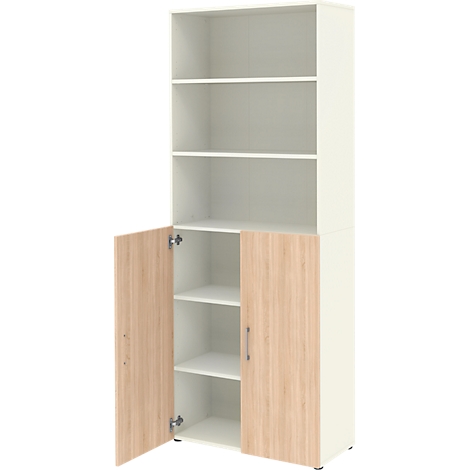 Grande armoire blanche avec portes aspect bois. Les portes sont ouvertes, révélant des étagères. Etagères au-dessus, vides.