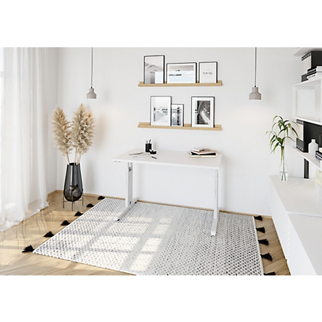 White desk with silver legs in modern home office, pictures on wall.
