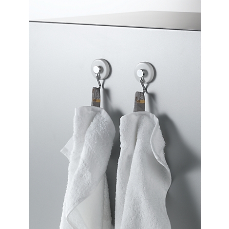 Two white towels hang on hooks. The background is light gray.