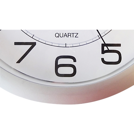 Gros plan d'une horloge avec les chiffres 7, 6 et 5. Le cadran est blanc avec un cadre argenté. Le texte 'QUARTZ' est en haut.