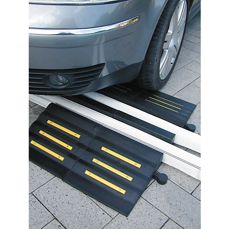 Black car ramp in front of car tire; yellow stripes.