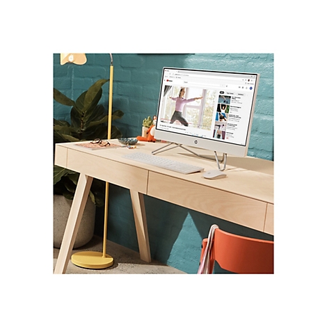 Ein weißer HP-All-in-One-PC steht auf einem Holzschreibtisch. Auf dem Bildschirm läuft ein Yoga-Video. Auf dem Tisch liegen eine Tastatur, eine Maus, eine Brille und Dekoration.