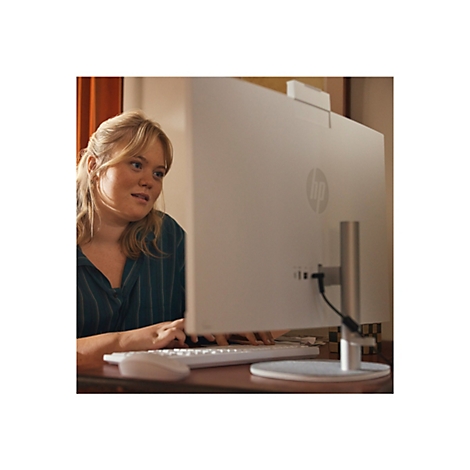 Eine Frau arbeitet an einem Computer mit HP-Logo. Sie trägt ein gestreiftes Hemd und schaut auf den Bildschirm.