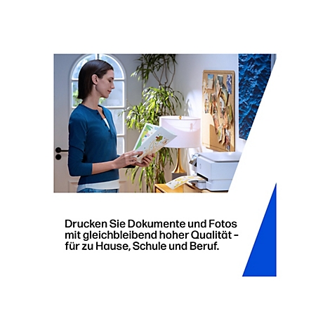 Une femme en haut bleu regarde des feuilles colorées tandis qu'une imprimante imprime en arrière-plan.