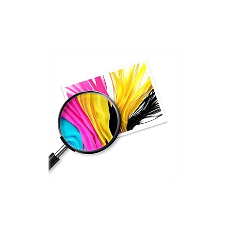 Une loupe grossit une feuille de papier avec des couleurs, dont le jaune, le rose, le cyan et le noir.