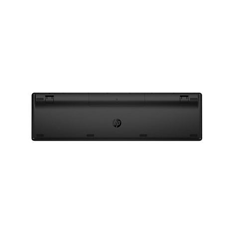 Die schwarze Unterseite einer HP Tastatur mit Gummifüßen und Batteriefachdeckel vor weißem Hintergrund.