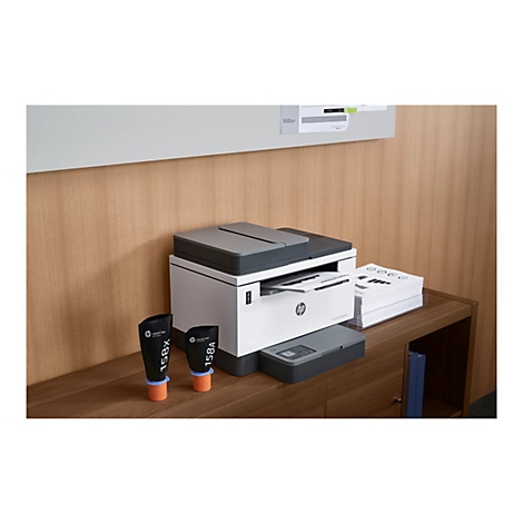 Büro mit HP-Drucker, Toner, Papierstapel und einem Schrank.