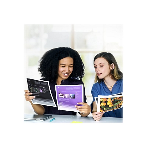 Zwei Frauen betrachten gemeinsam Dokumente mit Fotos und Diagrammen, die an einem Tisch liegen.