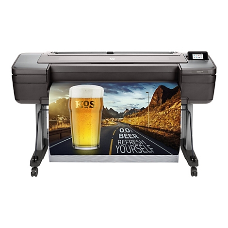Grande imprimante traceur HP Designjet Z6. Un verre à bière avec "KOS" sur le papier imprimé. Sur le papier, une route avec l'inscription "0,0% BEER REFRESH YOURSELF".